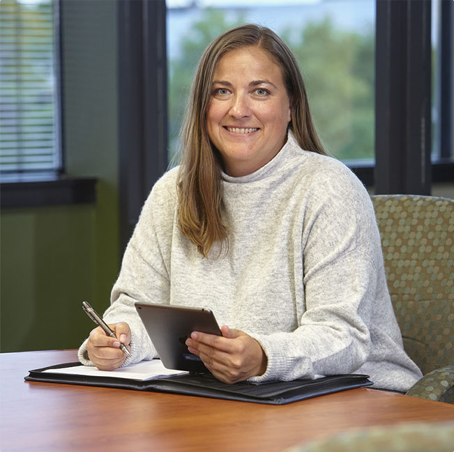 Employee smiling and sitting at office desk